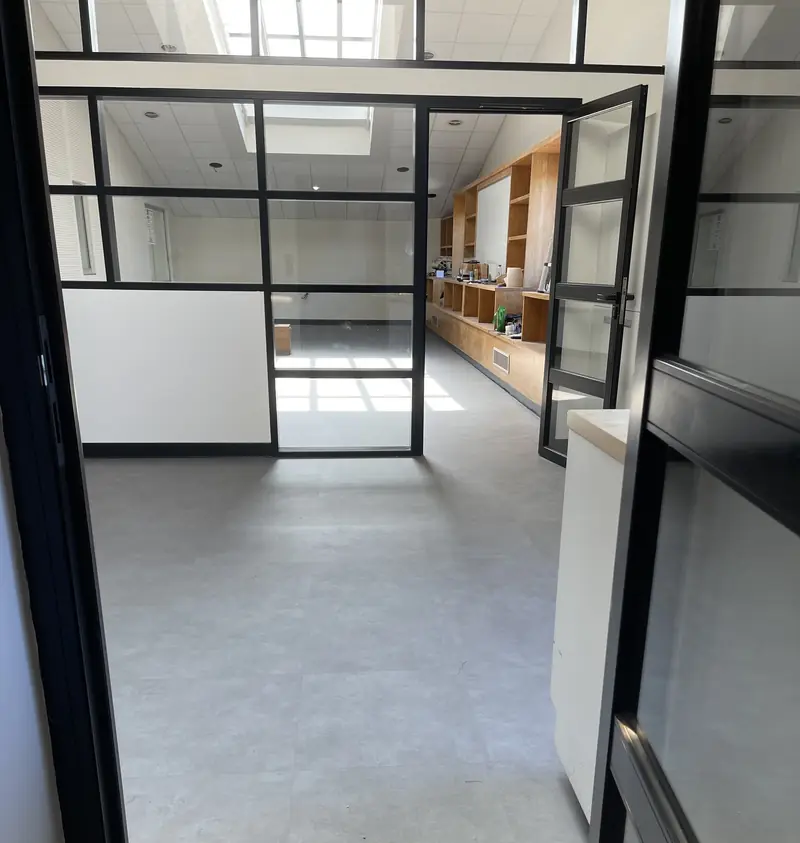 Dalles PVC effet béton posées dans des bureaux vitrés de Jacquet Metals à Saint-Priest